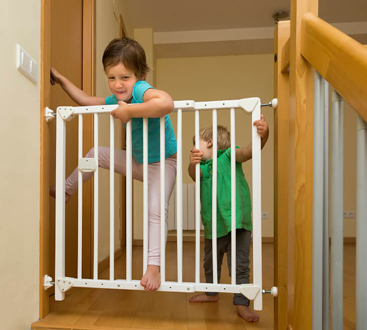 Little sisters near stair gate