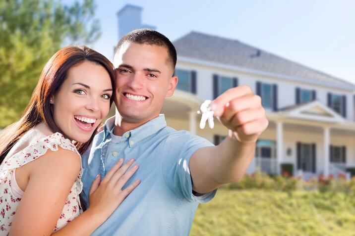 Mixed Race Excited Military Couple In Front of New Home Showing Off Their House Keys.