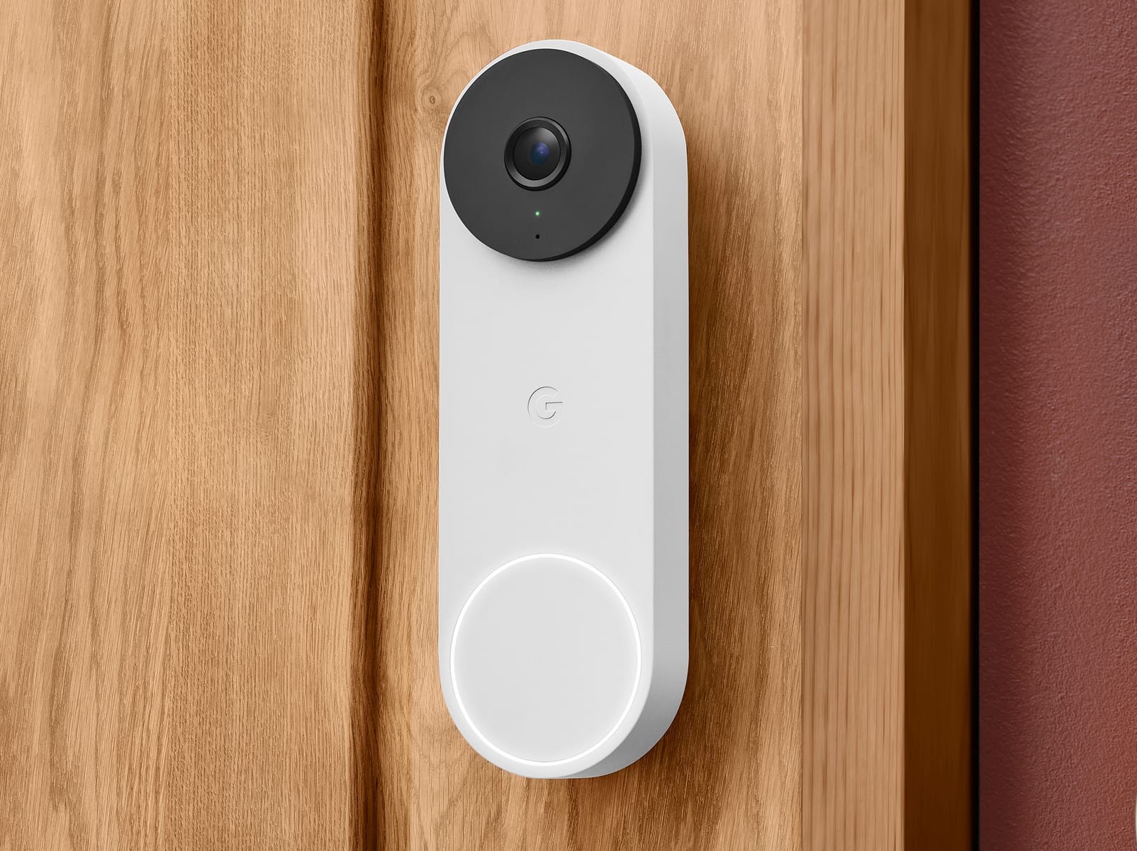 Google Nest Doorbell mounted on a wooden doorframe.
