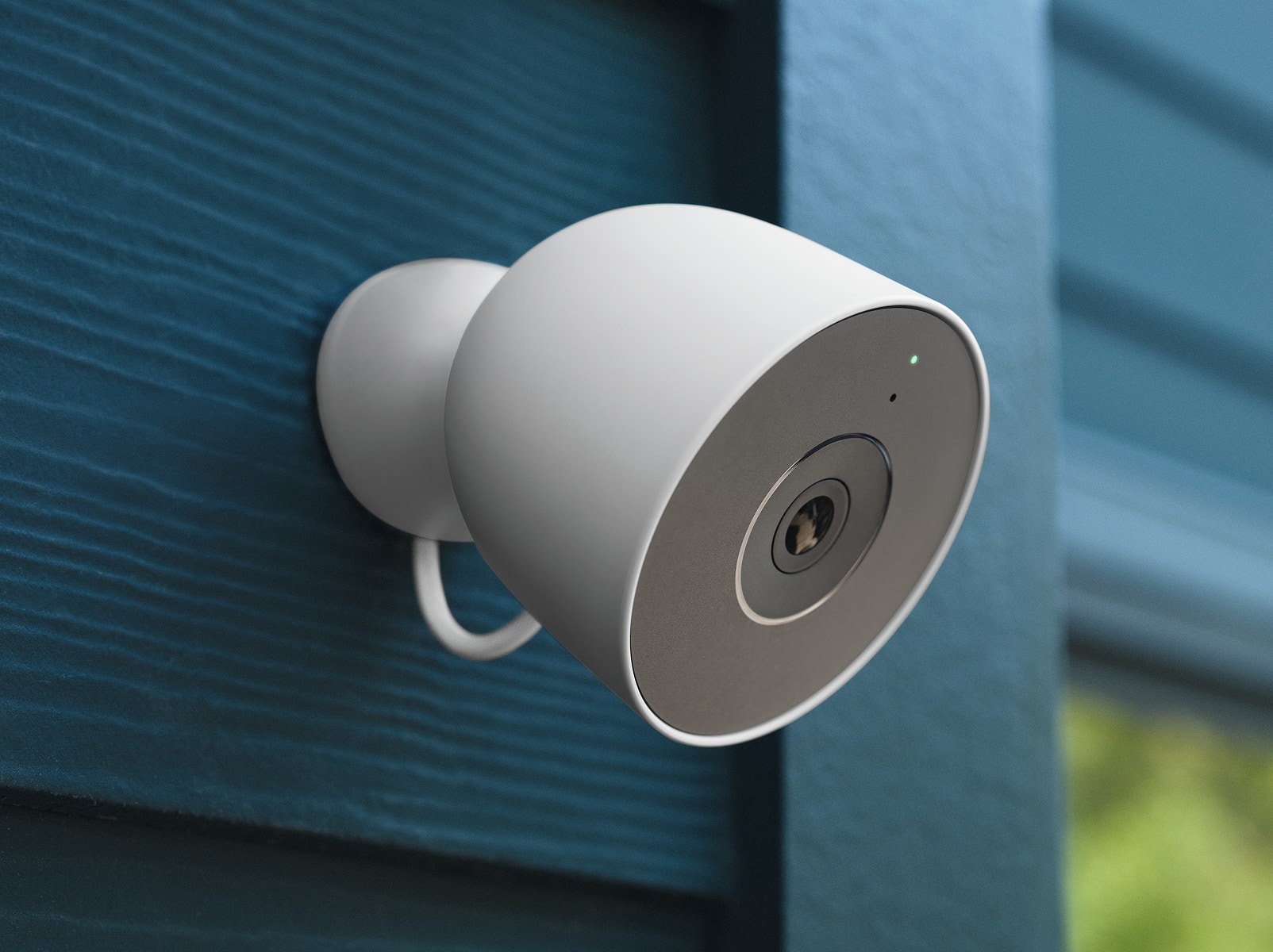 Google Nest Cam Outdoor mounted on blue exterior siding.